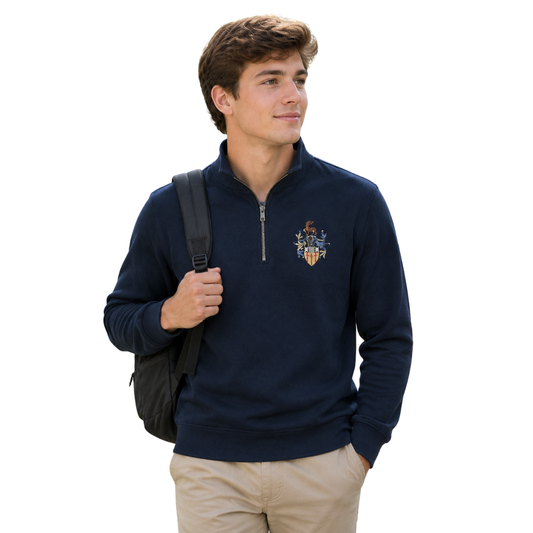 A man wearing a navy blue quarter-zip sweatshirt with the University of Surrey crest embroidered on the left chest, paired with khaki pants and carrying a black backpack, set against a plain white background.
